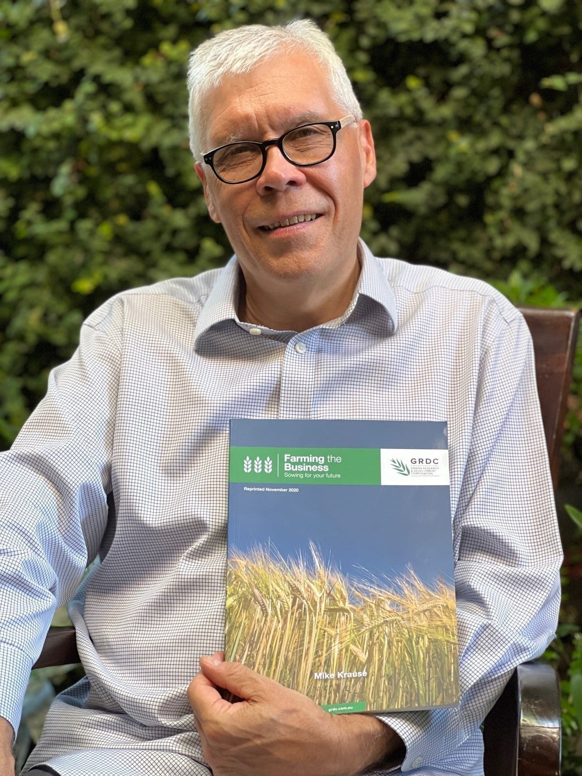 Mike Krause holding the Farming the Business manual he wrote for GRDC